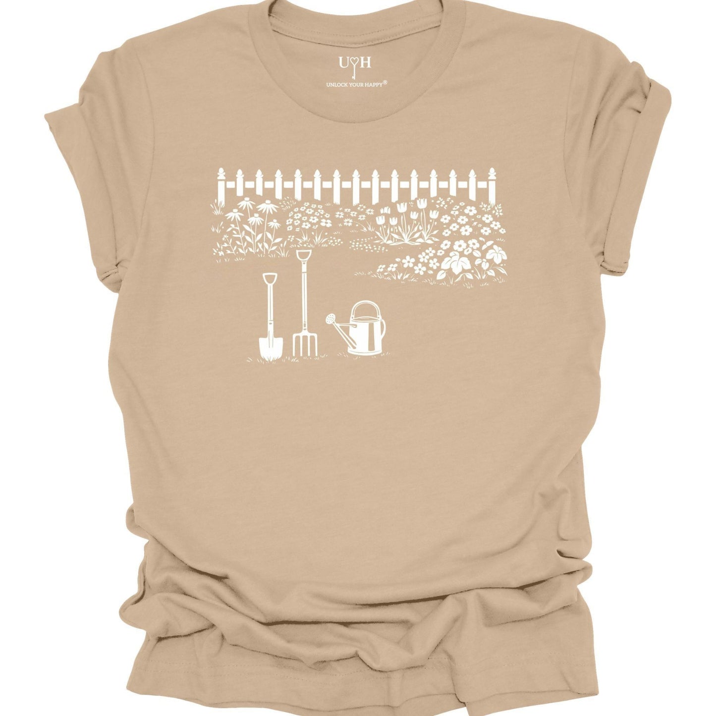 White gardening graphic on a tan t-shirt featuring garden tools and flower garden illustration with nature-inspired design