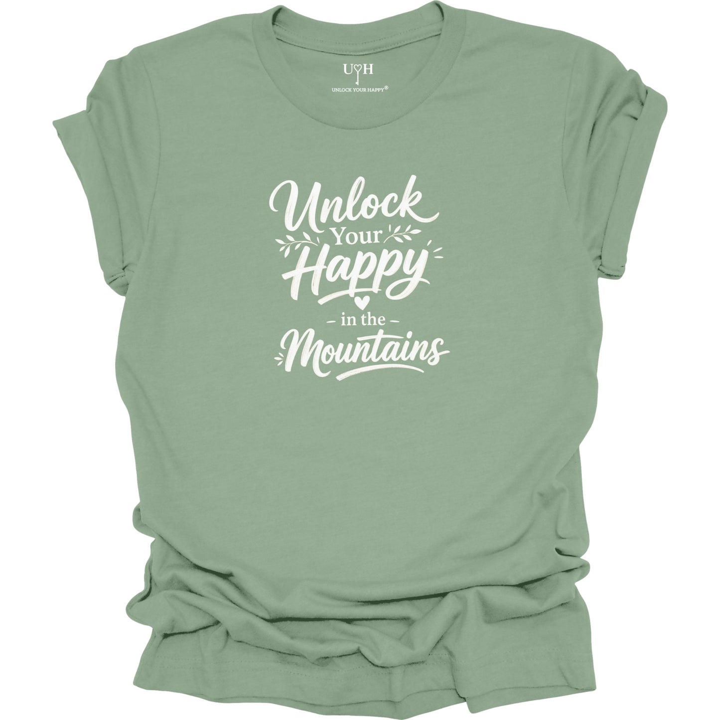 Sage green t-shirt with 'Unlock Your Happy in the Mountains' text on a white background