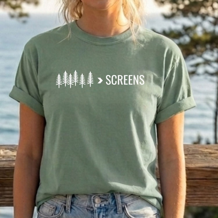 Man wearing a green t-shirt with 'NATURE HEALS' text in an open field with mountains behind 