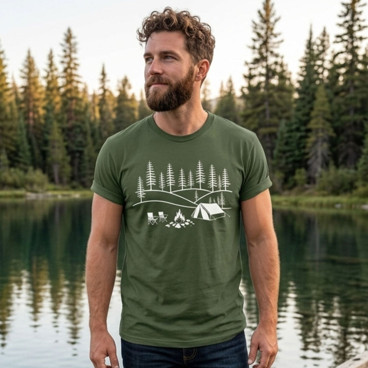 Image of a white graphic camping design on a moss green shirt with nature scene in background