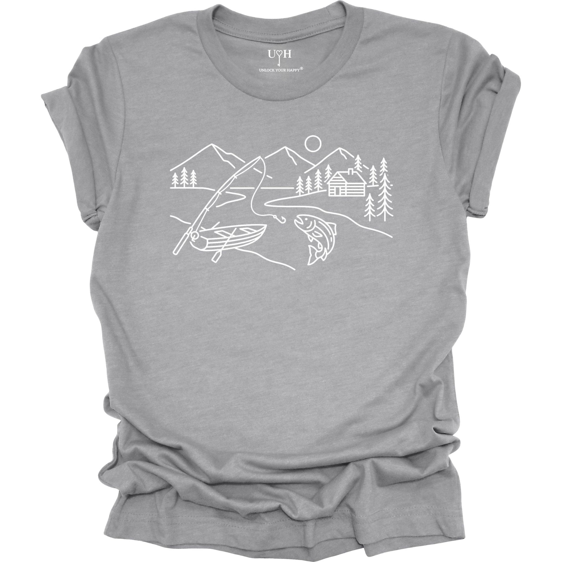 Gray t-shirt featuring a minimalist white line art fishing design with mountains, river, canoe, fish, cabin, and pine trees.
