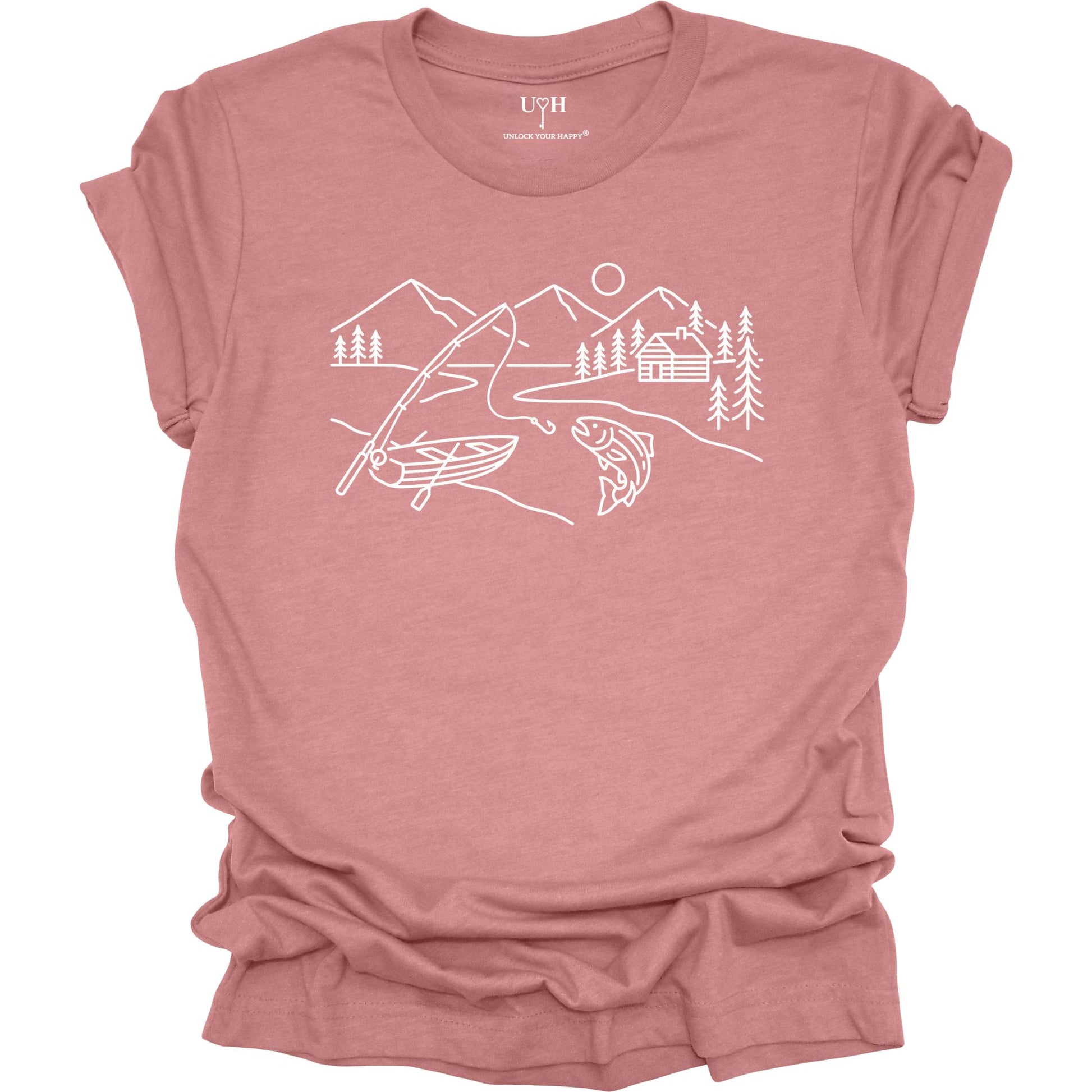 Mauve t-shirt featuring a minimalist white line art fishing design with mountains, river, canoe, fish, cabin, and pine trees.