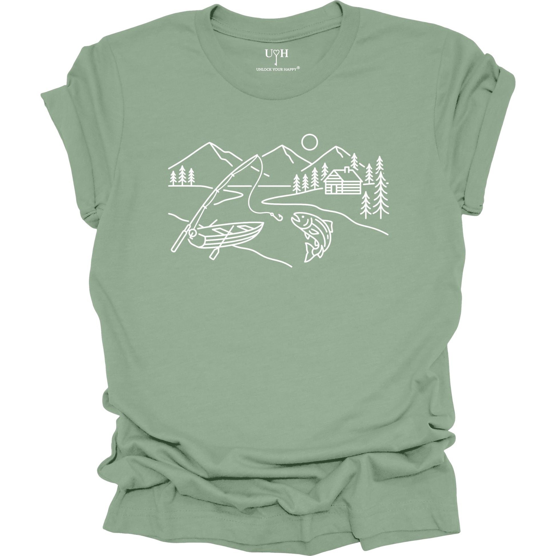 Sage t-shirt featuring a minimalist white line art fishing design with mountains, river, canoe, fish, cabin, and pine trees.