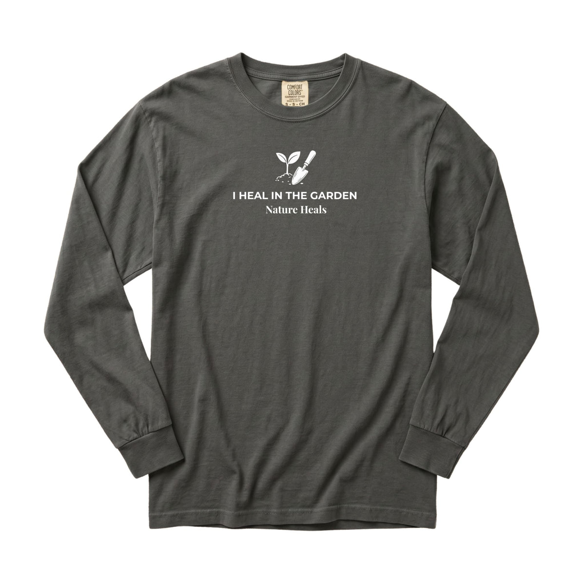 A pepper gray colored long-sleeve t-shirt with a white graphic on the chest showing a mound of soil, plant and trowel  and the text 'I HEAL IN THE GARDEN  Nature Heals'.