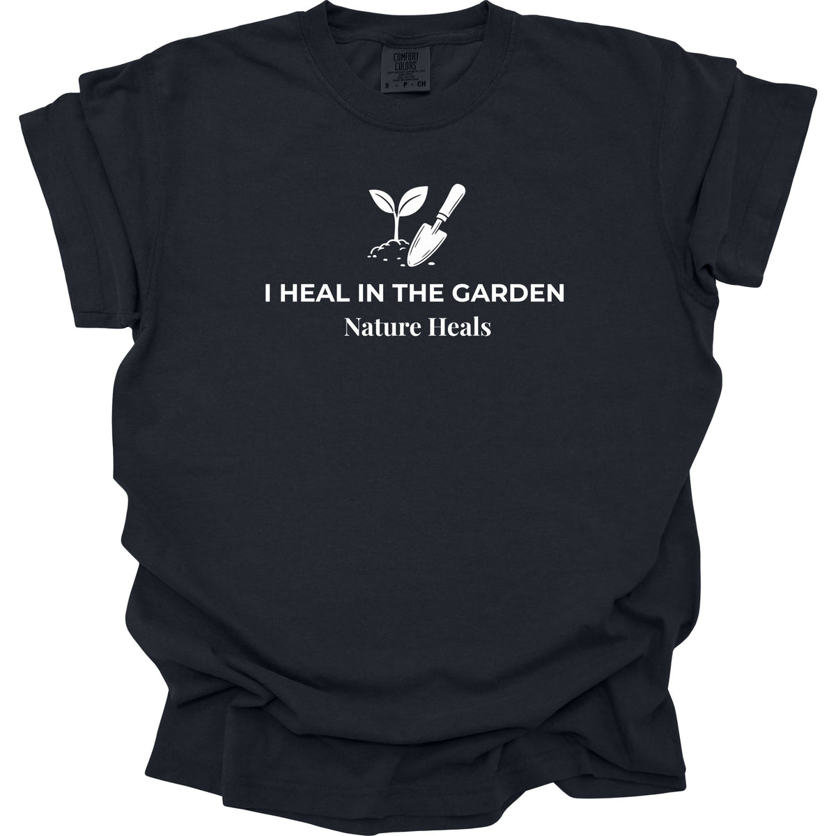 A black short-sleeve t-shirt with a white graphic print of a sprout and trowel with the text 'I HEAL IN THE GARDEN Nature Heals' on the front, displayed against a solid white background.