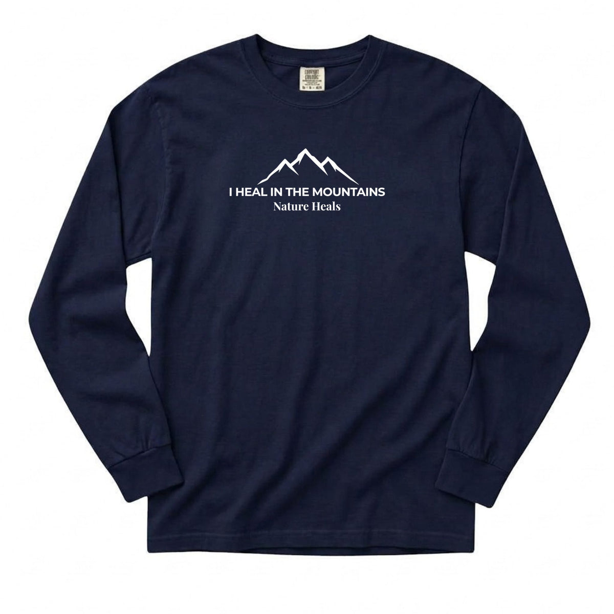 A navy blue long-sleeve t-shirt with a white graphic on the chest showing a mountain silhouette and the text 'I HEAL IN THE MOUNTAINS Nature Heals'.