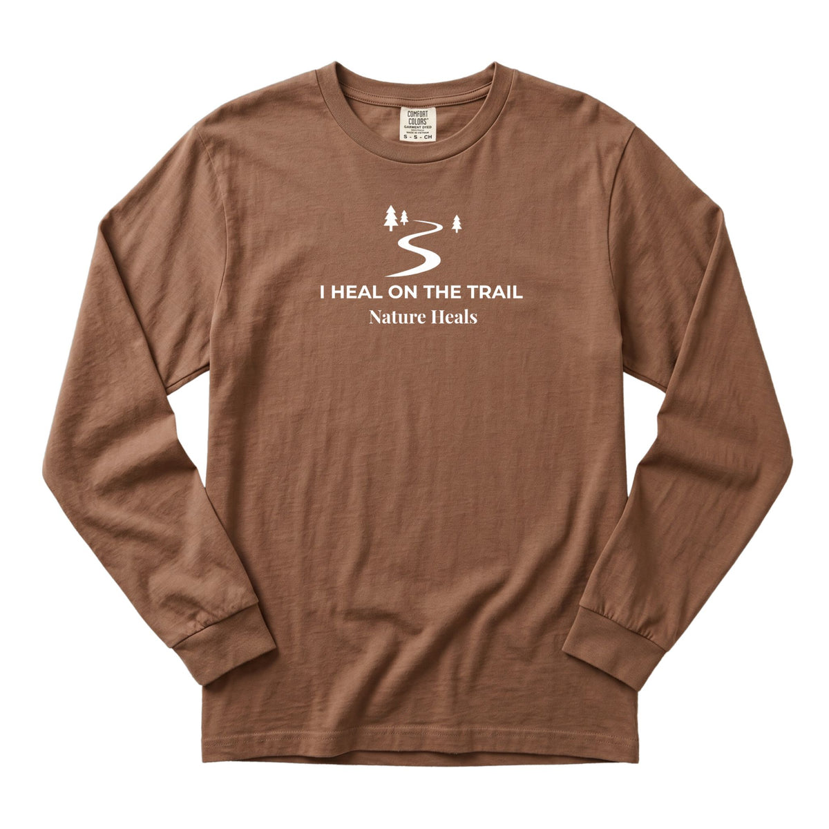 A brown long-sleeve crewneck t-shirt with a white graphic on the chest showing a winding trail and the text 'I HEAL ON THE TRAIL Nature Heals'.