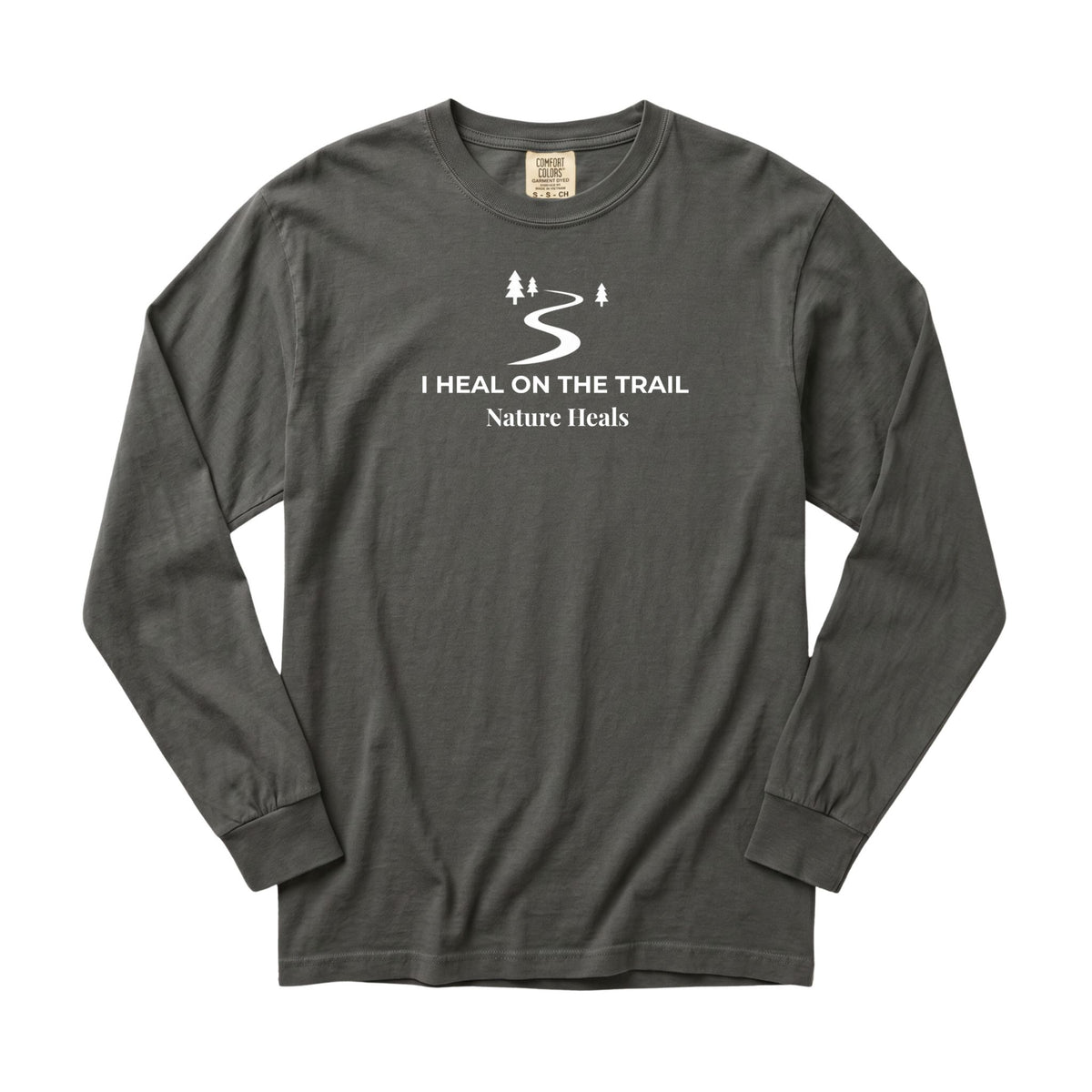 A dark gray long-sleeve t-shirt with a white graphic print on the chest showing a winding trail with a couple of trees and the text 'I HEAL ON THE TRAIL Nature Heals'.