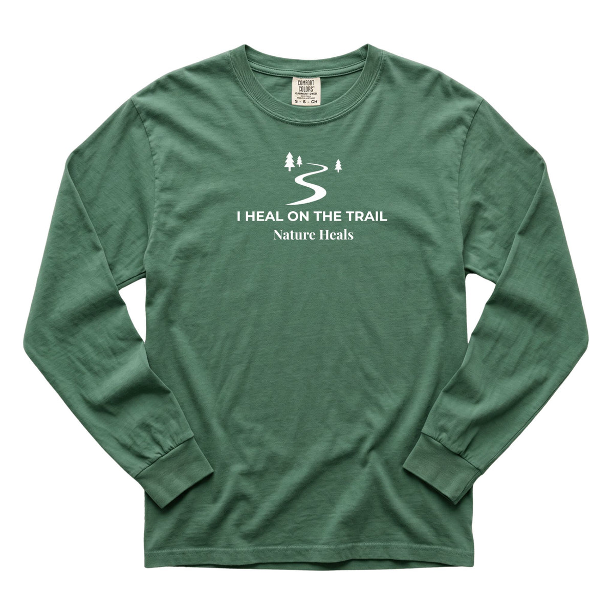 A green long-sleeve t-shirt with a white graphic on the chest showing a winding trail and the text 'I HEAL ON THE TRAIL Nature Heals'.