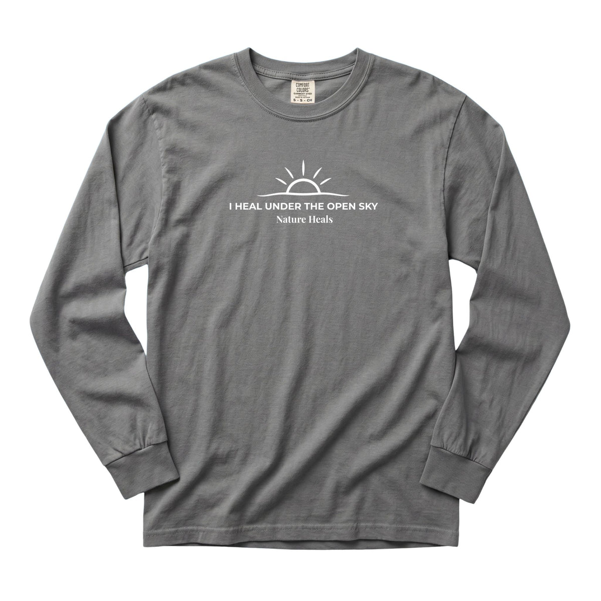 A gray long-sleeve t-shirt with a white graphic on the chest depicting a sun and the text 'I HEAL UNDER THE OPEN SKY Nature Heals'.