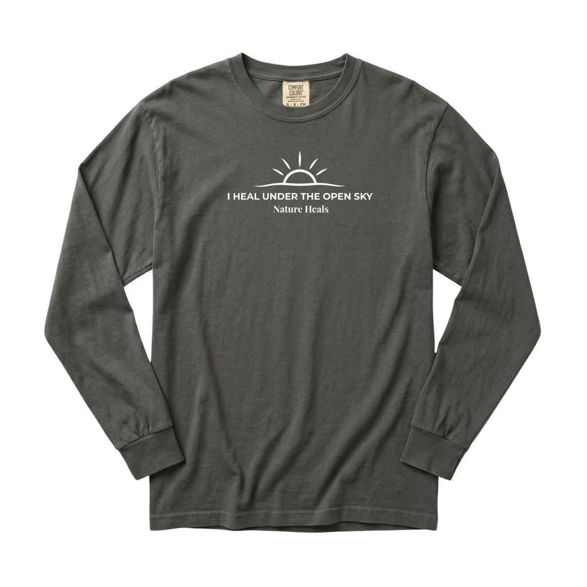 A pepper gray long-sleeve t-shirt with a white graphic print on the chest showing a sun and the text 'I HEAL UNDER THE OPEN SKY Nature Heals'.