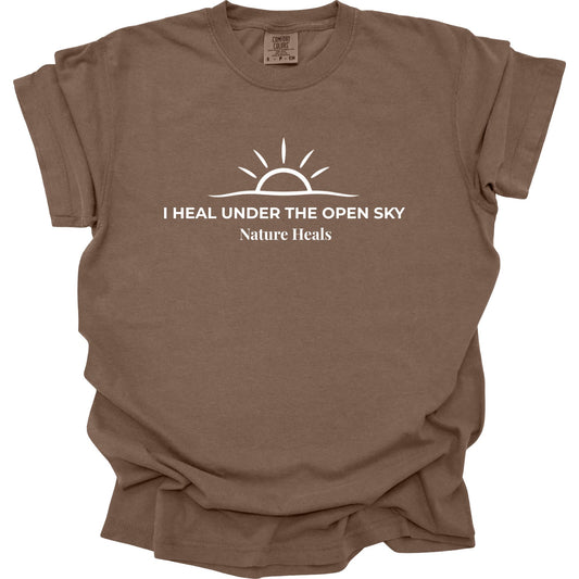 Nature Heals sun graphic shirt with “I Heal Under the Open Sky” and minimalist sunrise design on a Comfort Colors espresso brown tee.