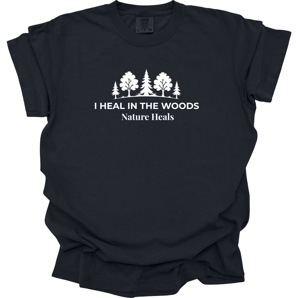 A black short-sleeve t-shirt with a white graphic print of trees and the text 'I HEAL IN THE WOODS Nature Heals' on the chest, displayed against a solid white background.