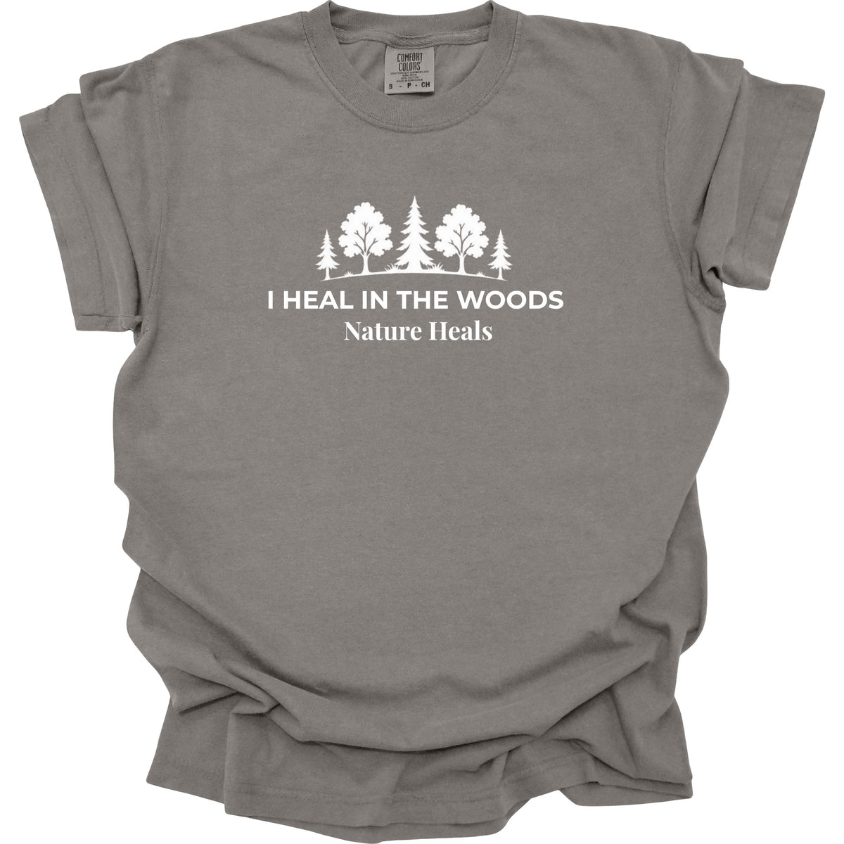 A gray short-sleeve crewneck t-shirt with a white graphic print of trees and the text 'I HEAL IN THE WOODS Nature Heals' on the chest, displayed against a plain white background.