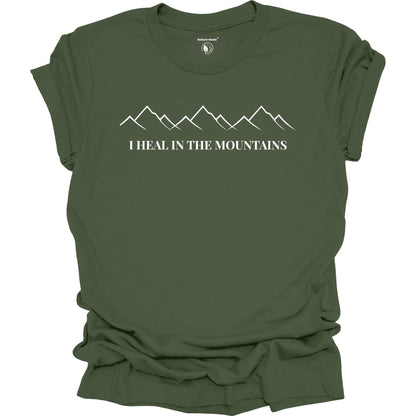 Green t-shirt with mountain graphic and text 'I Heal in the Mountains' on a white background