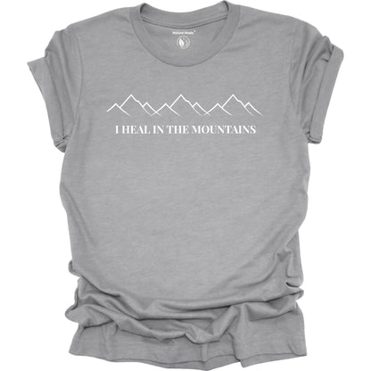 Gray t-shirt with mountain design and text 'I Heal in the Mountains' on a white background