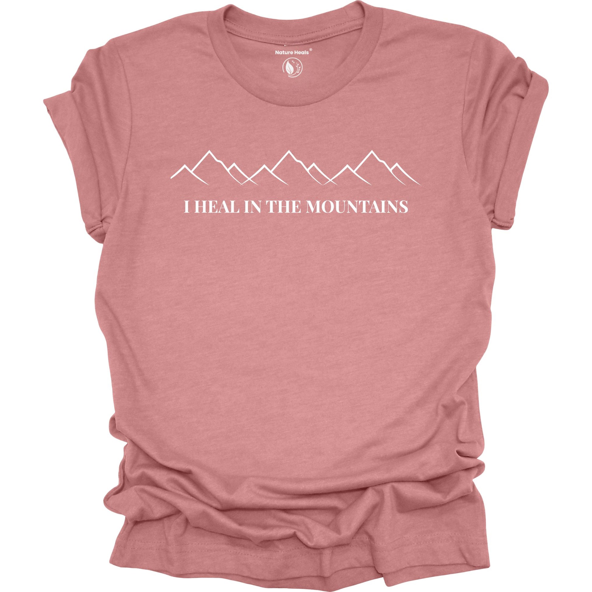 Mauve t-shirt with mountain graphic and text 'I Heal in the Mountains' on a white background