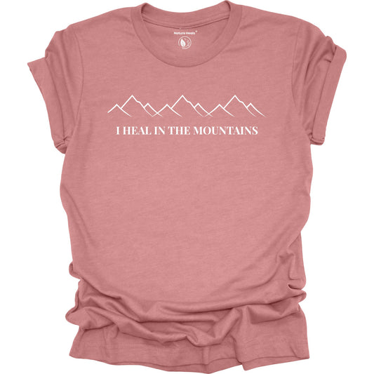 Mauve t-shirt with mountain graphic and text 'I Heal in the Mountains' on a white background