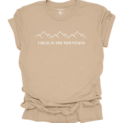 Tan t-shirt with mountain graphic and text 'I Heal in the Mountains' on a white background