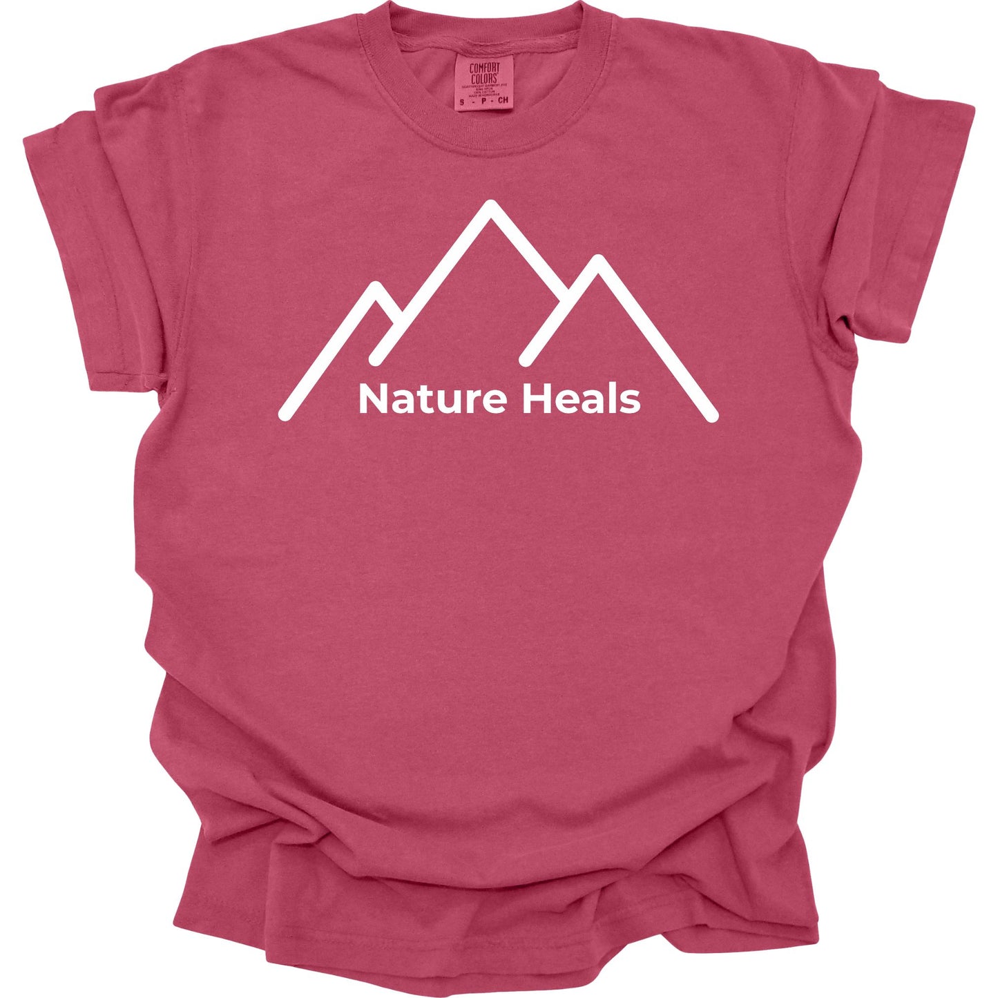 Brick colored t-shirt with white mountain graphic and 'Nature Heals' text on a white background
