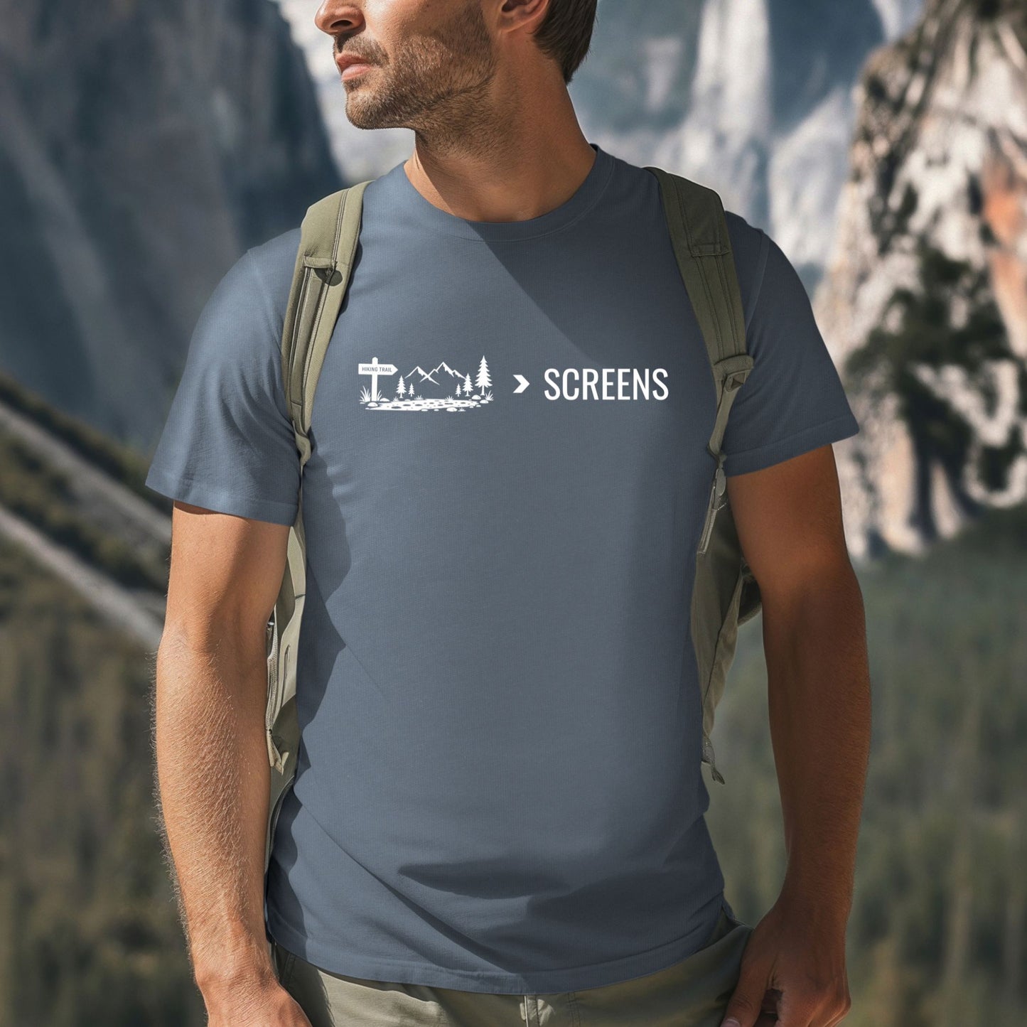 Man wearing a Nature Over Screens blue t-shirt featuring mountains and trees 