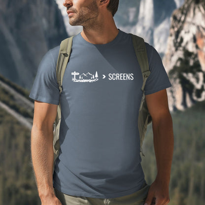 Man wearing a Nature Over Screens blue t-shirt featuring mountains and trees 