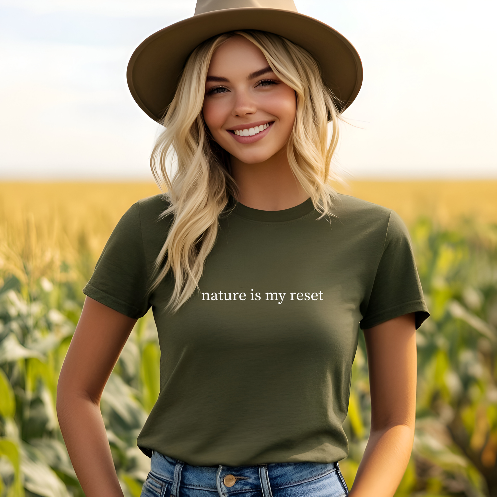 Woman wearing a green t-shirt with 'nature is my reset' text in a field.