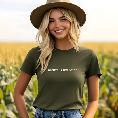 Woman wearing a green t-shirt with 'nature is my reset' text in a field.