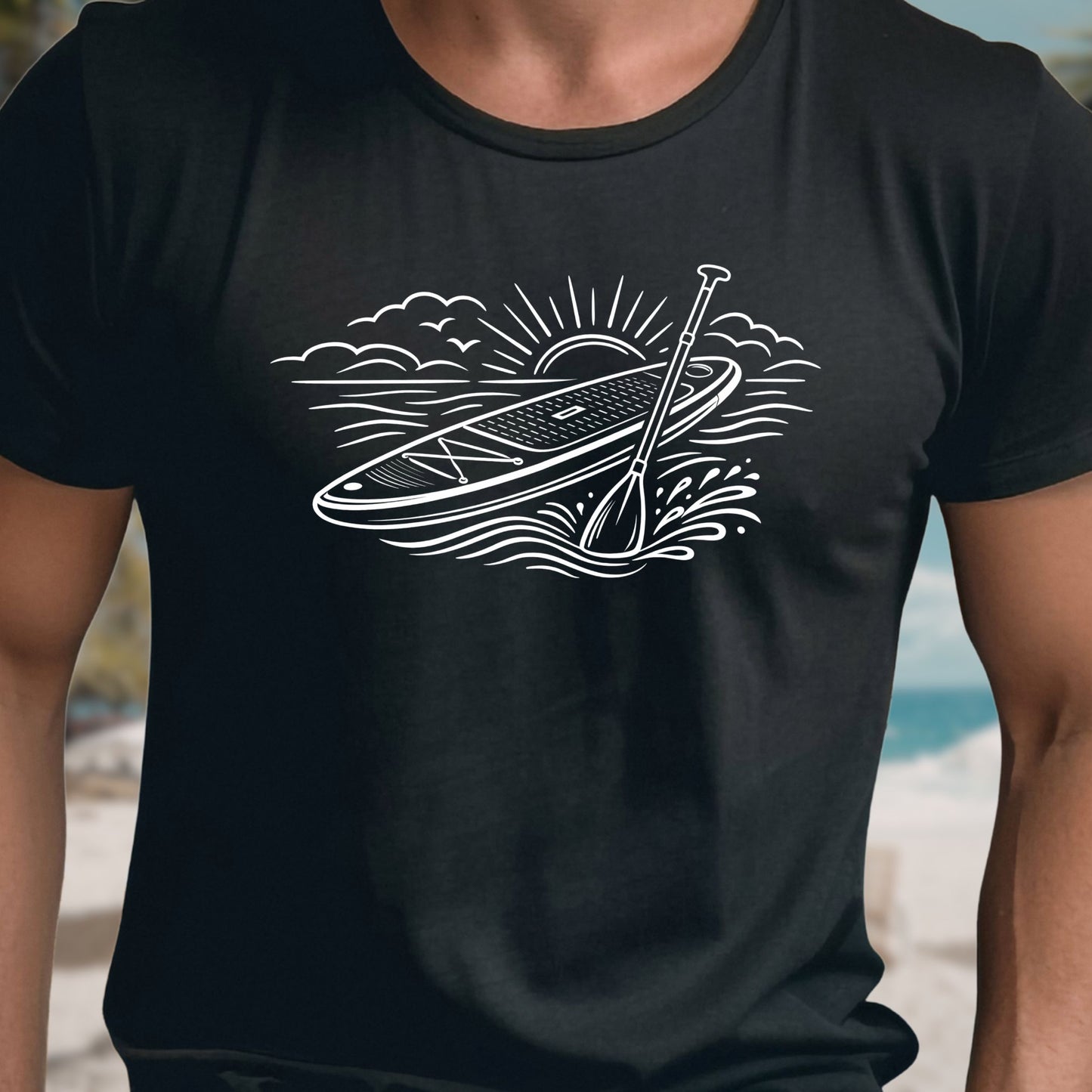 Black t-shirt featuring white line art of a stand up paddle board with paddle on water at sunrise, worn by model, ocean and beach lifestyle design