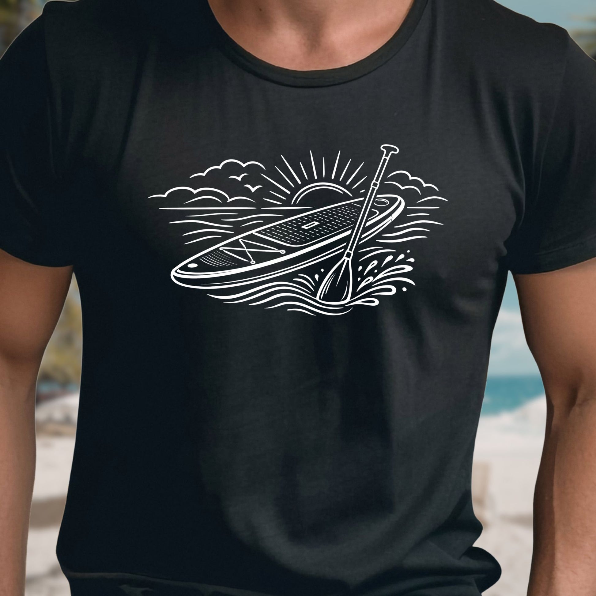 Black t-shirt featuring white line art of a stand up paddle board with paddle on water at sunrise, worn by model, ocean and beach lifestyle design