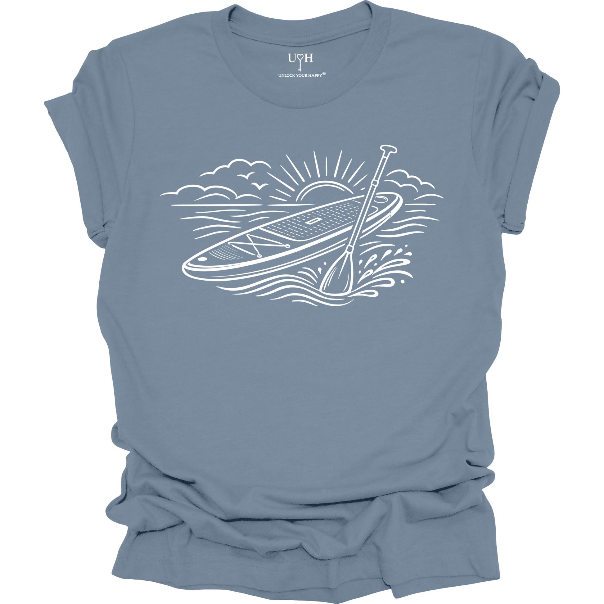 Blue t-shirt featuring white line art of a stand up paddle board with paddle on water at sunrise, worn by model, ocean and beach lifestyle design
