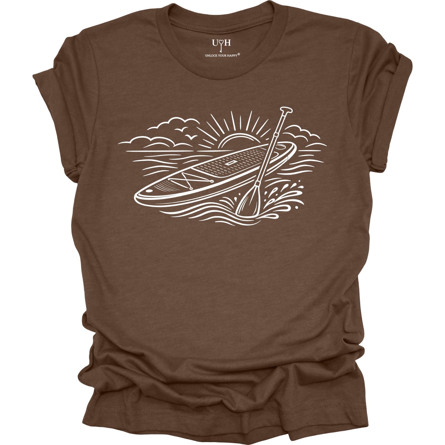 Brown t-shirt featuring white line art of a stand up paddle board with paddle on water at sunrise, worn by model, ocean and beach lifestyle design