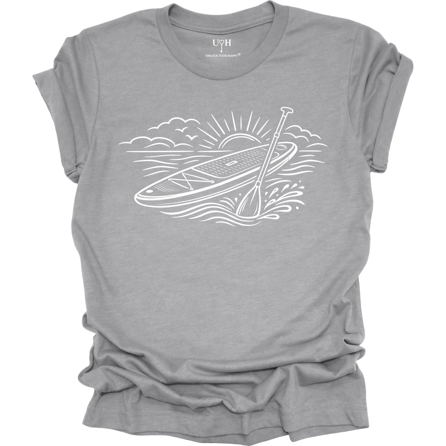 Gray t-shirt featuring white line art of a stand up paddle board with paddle on water at sunrise ocean and beach lifestyle design