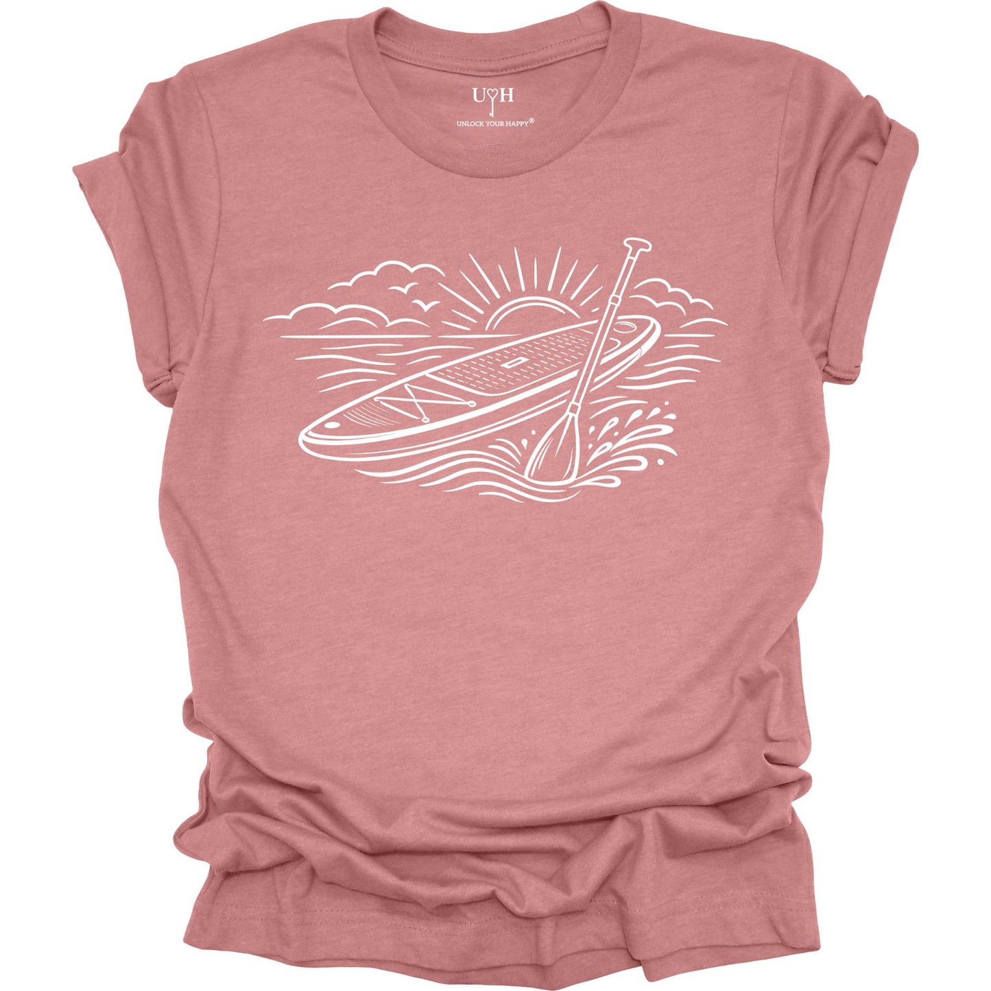 Mauve t-shirt featuring white line art of a stand up paddle board with paddle on water at sunrise, worn by model, ocean and beach lifestyle design