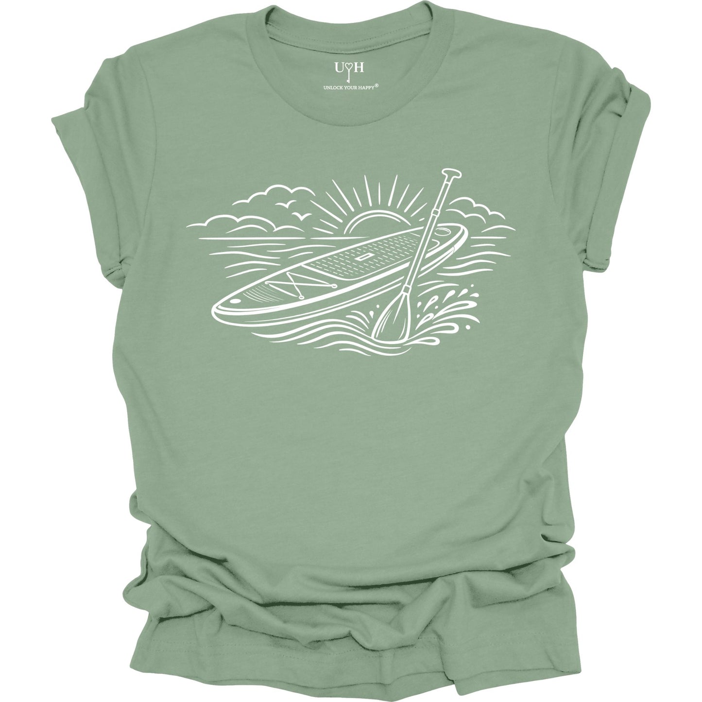 Sage t-shirt featuring white line art of a stand up paddle board with paddle on water at sunrise, worn by model, ocean and beach lifestyle design
