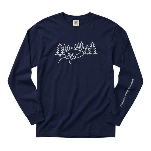 A long-sleeve crewneck t-shirt in a navy blue color, featuring a white line art graphic of pine trees, a winding road, and a bicycle on the chest, with 'Unlock Your Happy' printed vertically in white on the left sleeve.