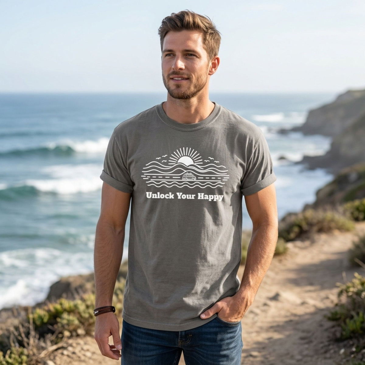 Unlock Your Happy camper van road trip T-shirt in grey Comfort Colors with nature and sun design on male near ocean