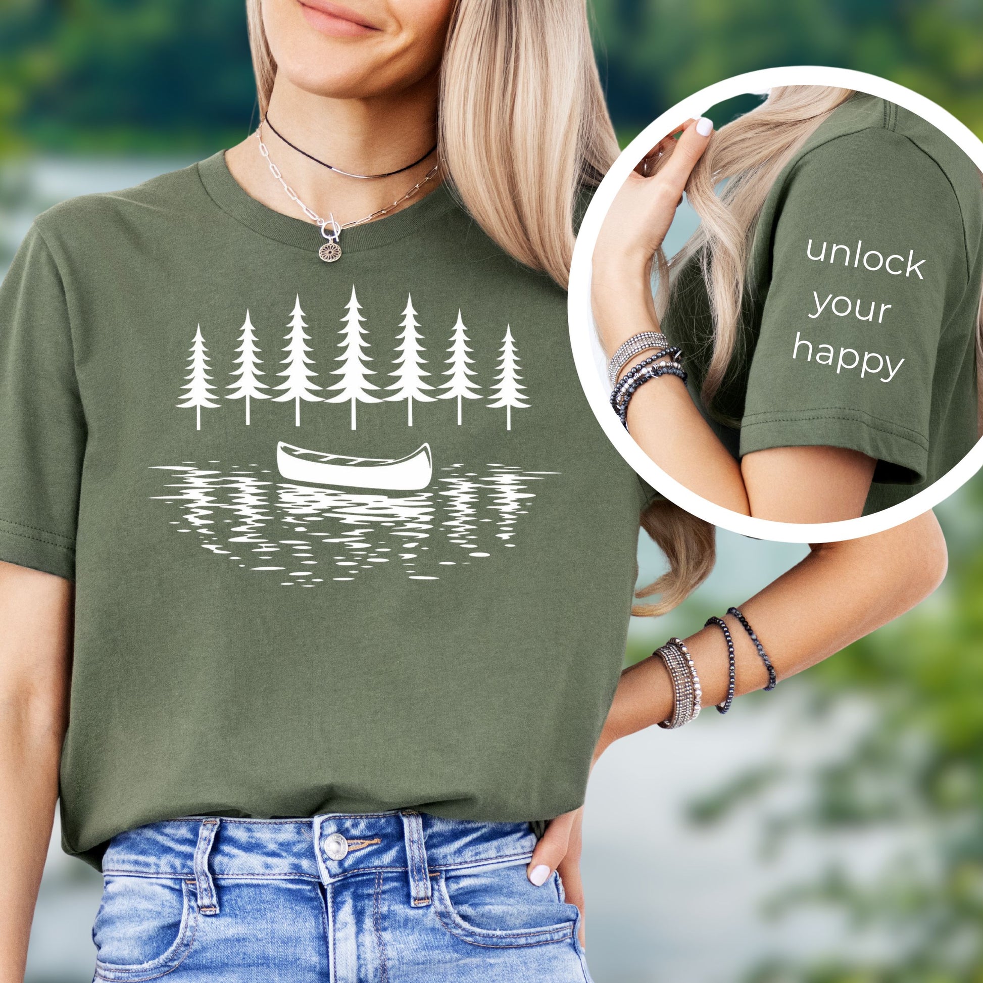 Person wearing a green t-shirt with a white line art canoe and lake nature graphic and text 'unlock your happy' on sleeve.