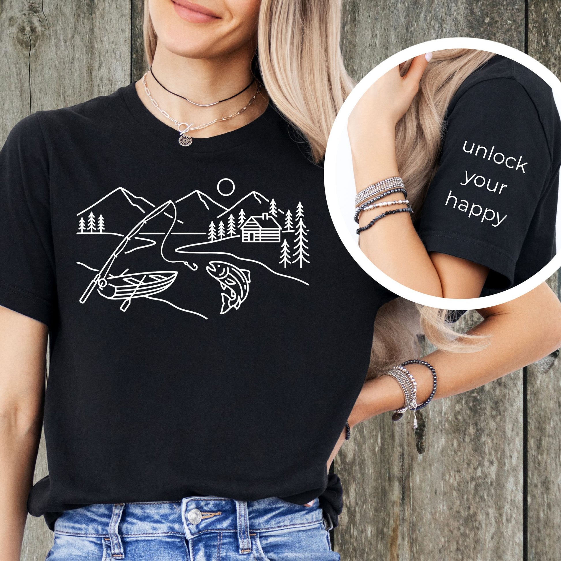 Person wearing a black t-shirt with a fishing graphic and 'unlock your happy' text on sleeve