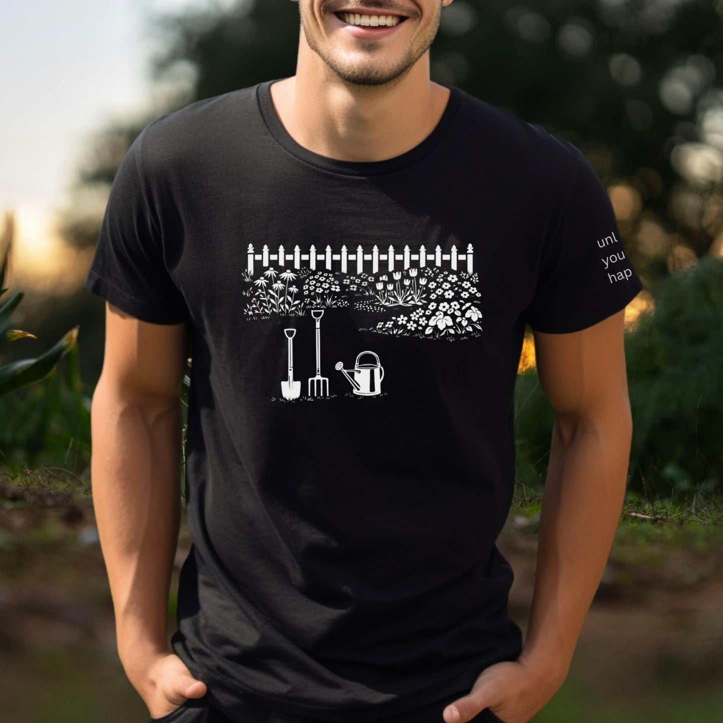 Male wearing a white graphic gardening design black  t-shirt with unlock your happy text on sleeve standing outdoors.