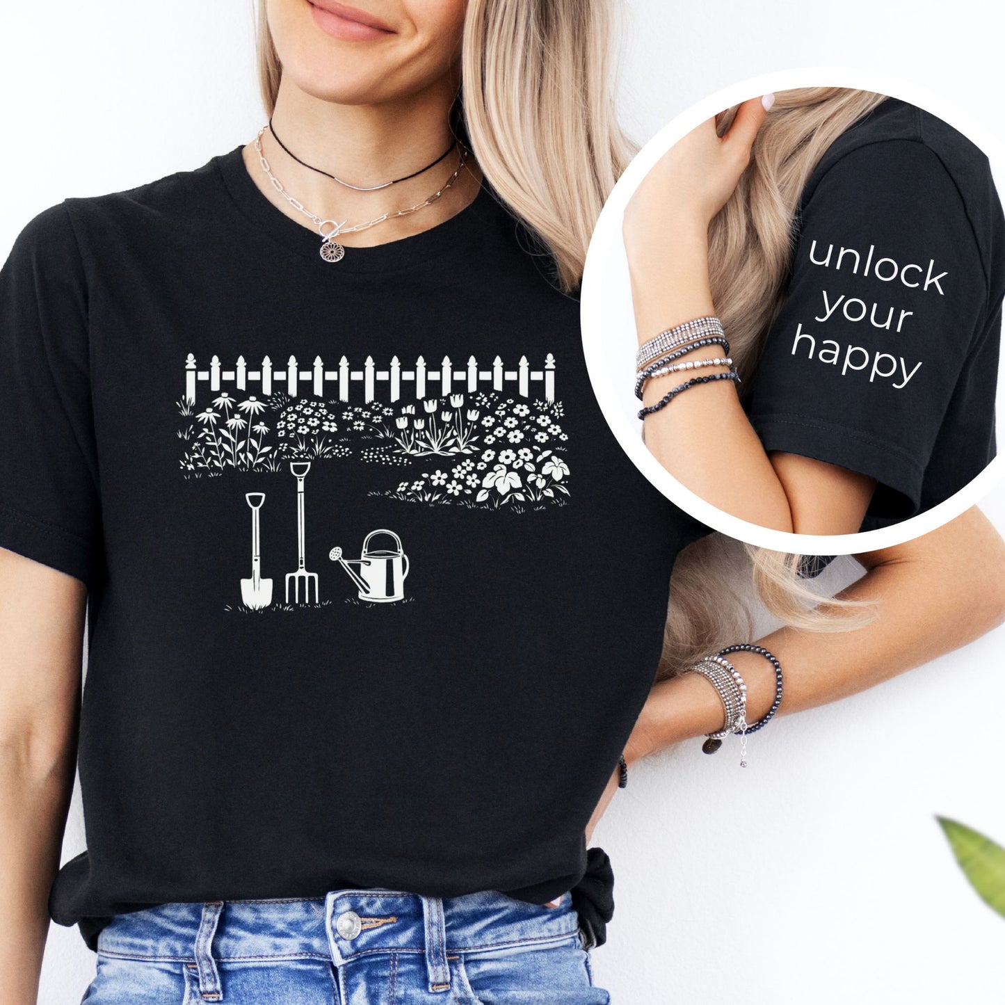 Female wearing a white graphic gardening design black  t-shirt with unlock your happy text on sleeve.