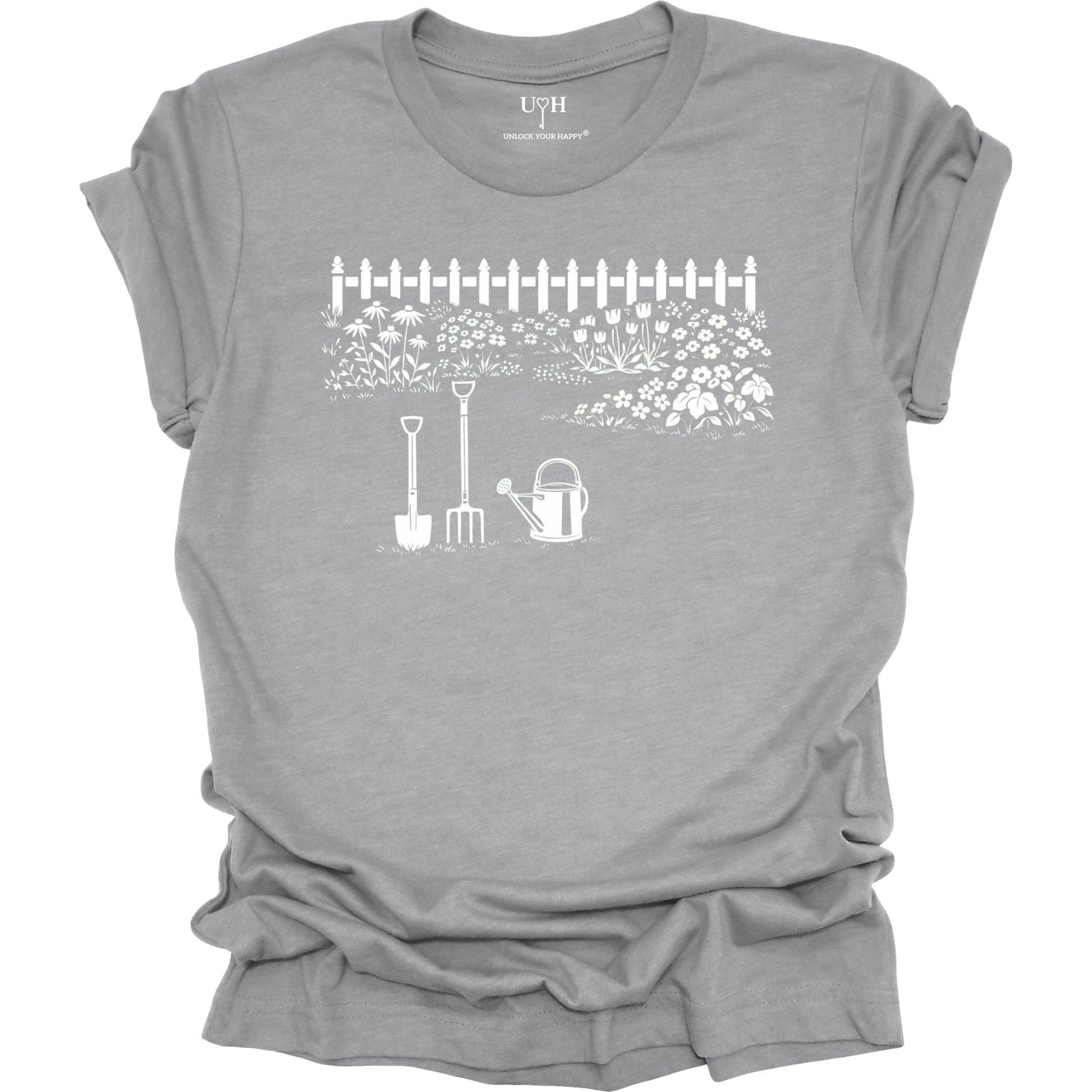 White gardening graphic on a gray t-shirt featuring garden tools and flower garden illustration with nature-inspired design 