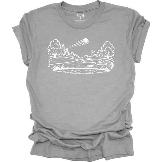 Minimalist golf course graphic t-shirt with line art design of golf ball and green on soft unisex gray
 tee