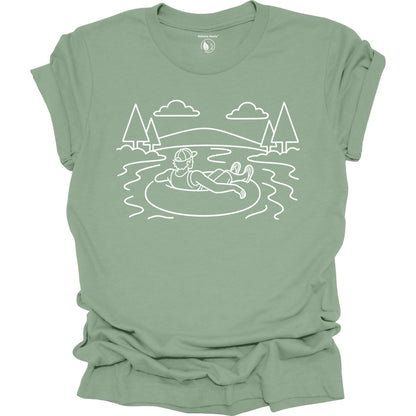 Sage t-shirt with a white line art design of a person in a lake surrounded by trees on a white background.