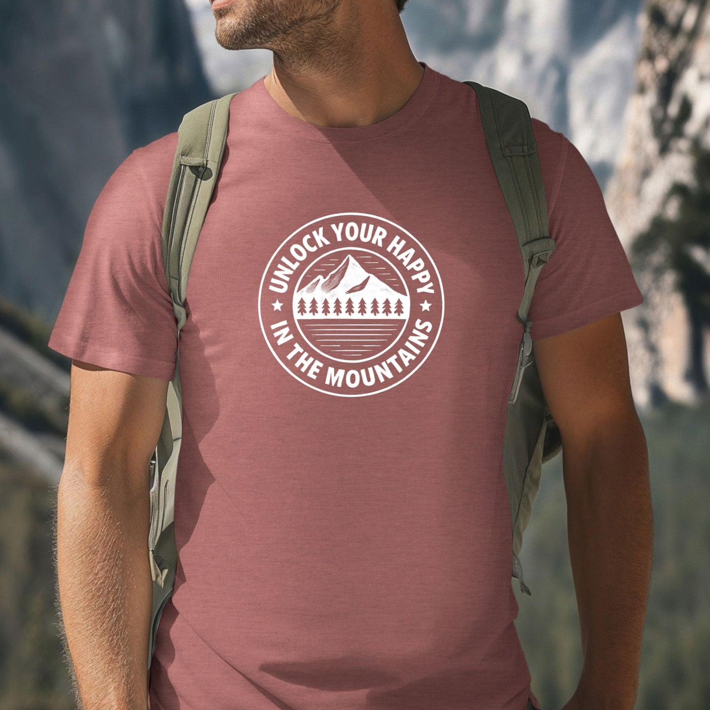 Mauve unisex graphic t-shirt featuring a circular mountain and pine tree design with the text “Unlock Your Happy in the Mountains” on a female in the mountains.