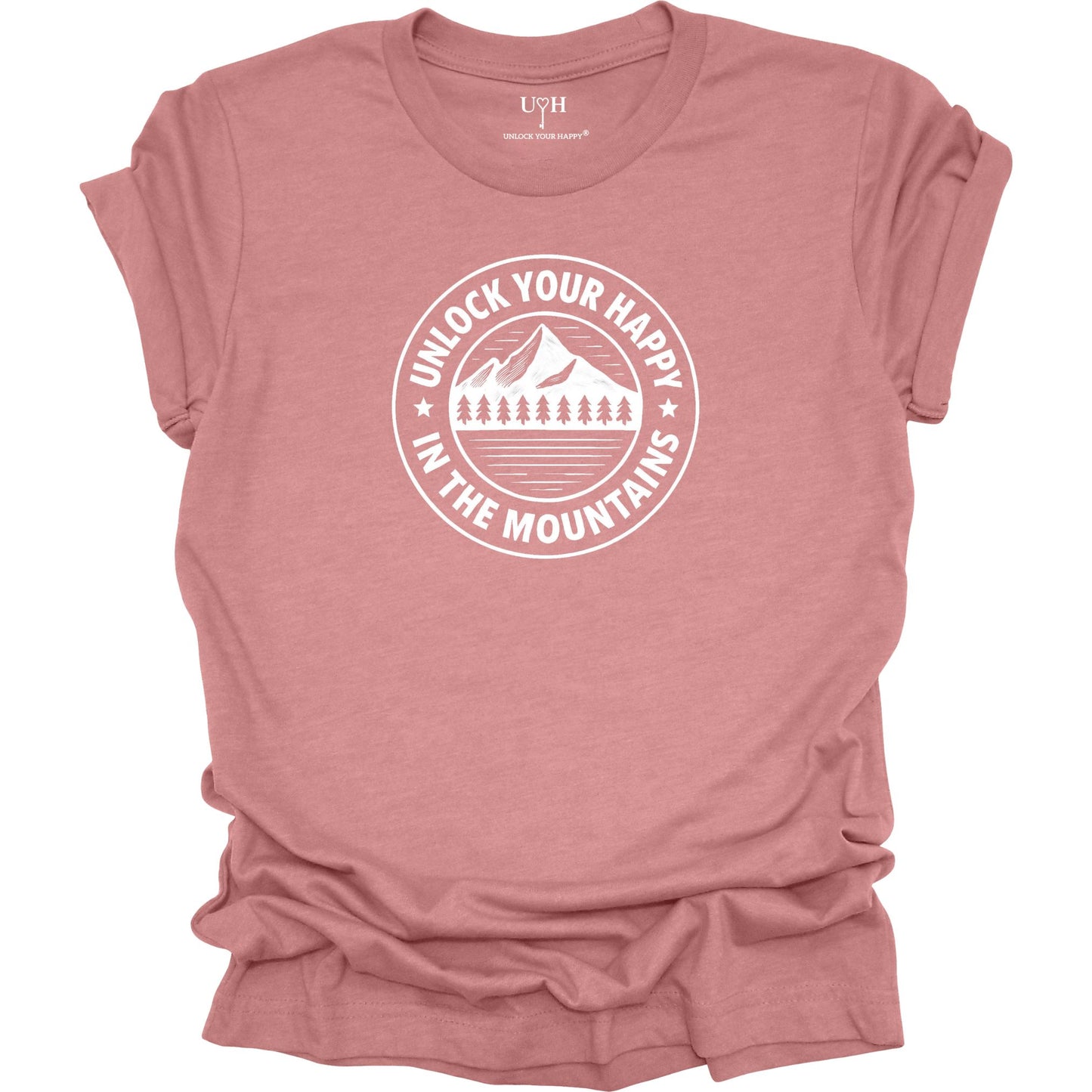 Mauve unisex graphic t-shirt featuring a circular mountain and pine tree design with the text “Unlock Your Happy in the Mountains”.