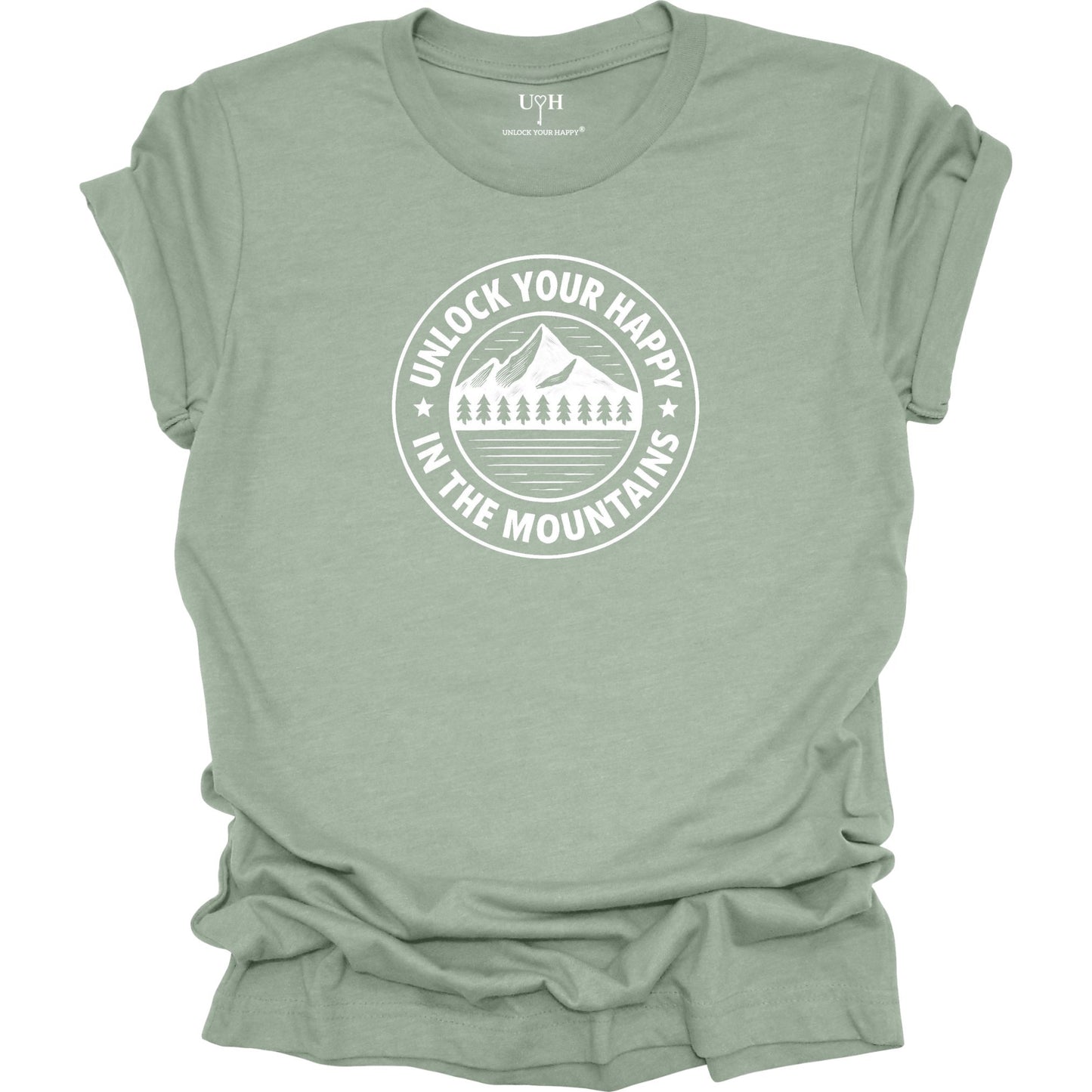 Sage unisex graphic t-shirt featuring a circular mountain and pine tree design with the text “Unlock Your Happy in the Mountains”.