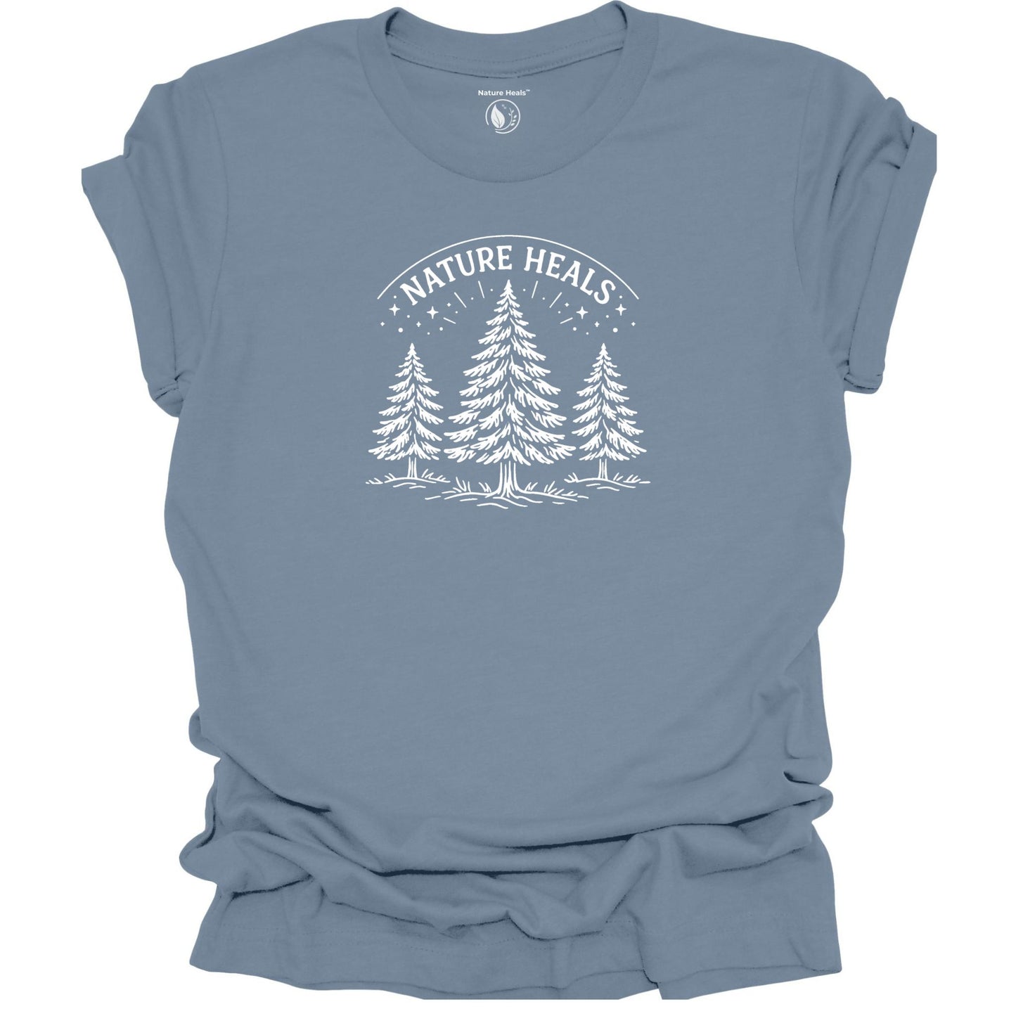 Minimalist Nature Heals t-shirt with pine tree graphic on blue fabric, designed for nature lovers, wellness, and outdoor lifestyle