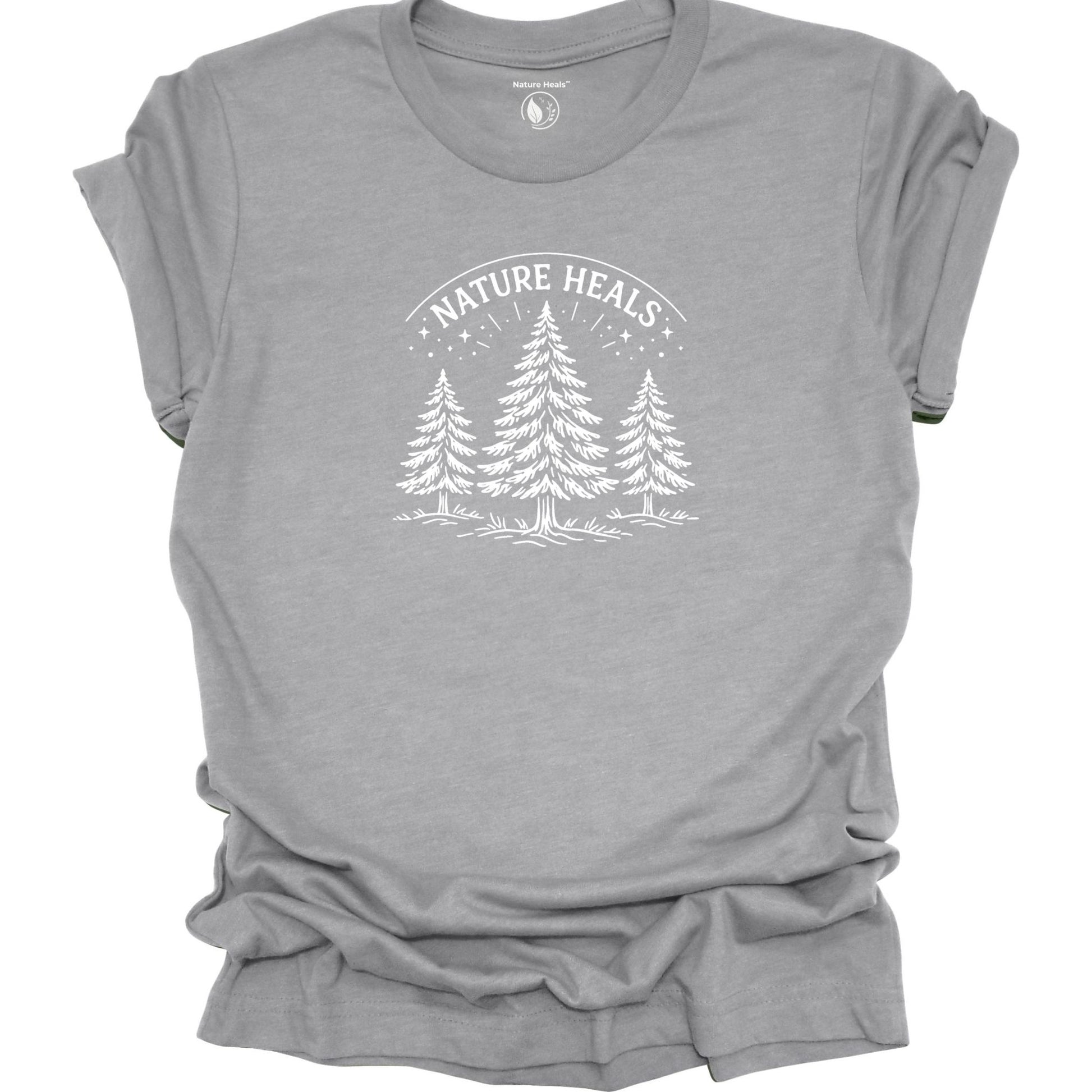 Minimalist Nature Heals t-shirt with pine tree graphic on gray fabric, designed for nature lovers, wellness, and outdoor lifestyle