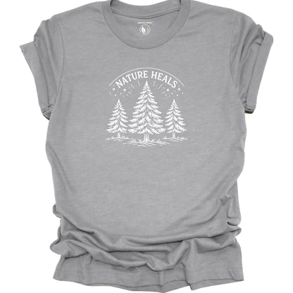 Minimalist Nature Heals t-shirt with pine tree graphic on gray fabric, designed for nature lovers, wellness, and outdoor lifestyle